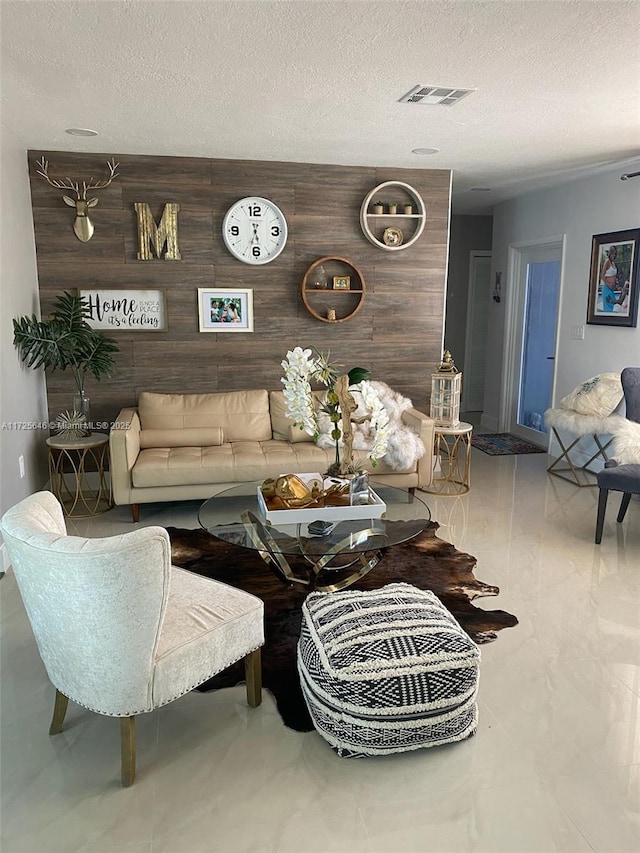 living room with a textured ceiling and wooden walls