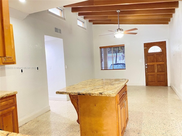 6181 SW 20th St, West Miami, FL 33155 - kitchen with ceiling fan, baseboards, beam ceiling, dark aggregate flooring, and light stone countertops