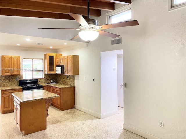 6181 SW 20th St, West Miami, FL 33155 - kitchen with black gas stove, tasteful backsplash, a center island, brown cabinetry, and ornamental molding