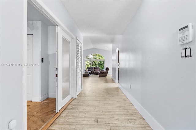 hall featuring lofted ceiling