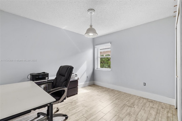 office space with a textured ceiling and light hardwood / wood-style floors