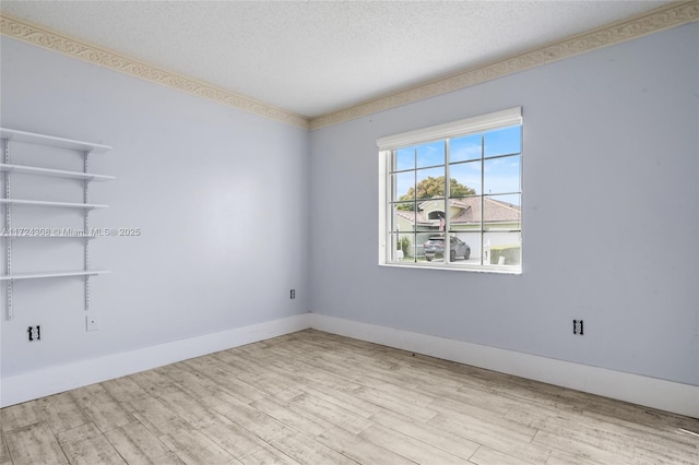 unfurnished room with a textured ceiling and light hardwood / wood-style flooring