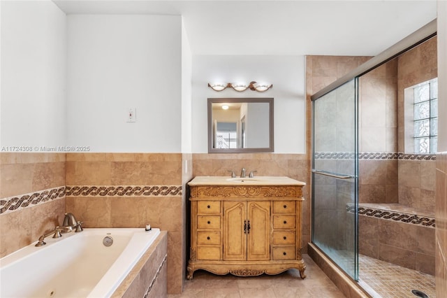 bathroom with tile walls, tile patterned flooring, plus walk in shower, and vanity