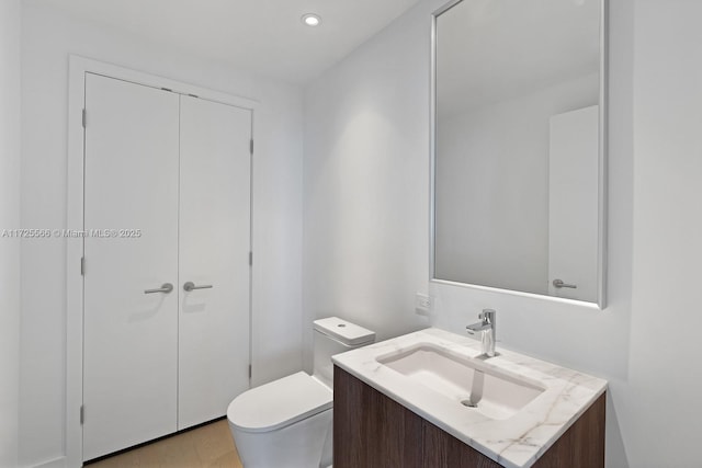 bathroom featuring toilet, wood-type flooring, and vanity