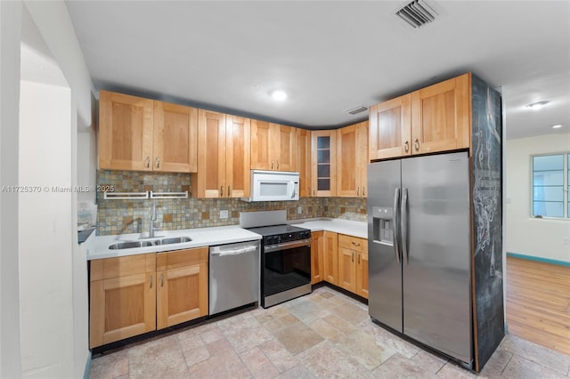 kitchen with stainless steel appliances, backsplash, and sink