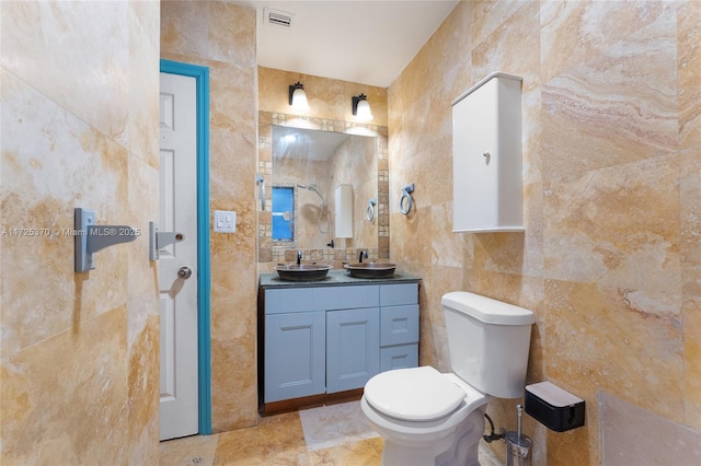 bathroom featuring tile walls, vanity, and toilet