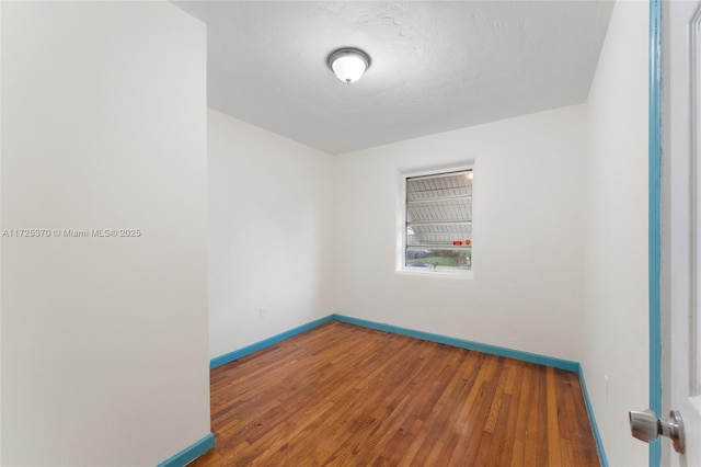 empty room featuring wood-type flooring and a textured ceiling