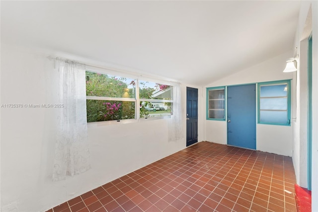 spare room featuring lofted ceiling