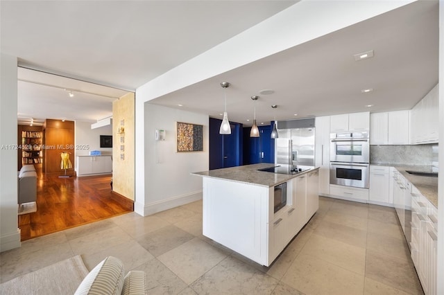 kitchen featuring black appliances, stone counters, a kitchen island, white cabinets, and backsplash