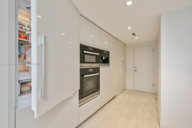 kitchen with white cabinets and light hardwood / wood-style floors