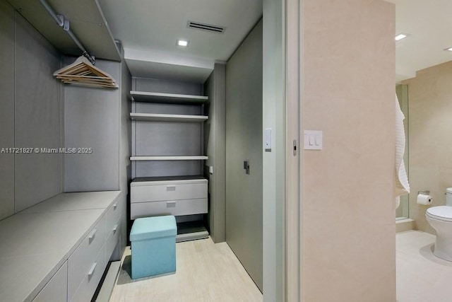 spacious closet with light hardwood / wood-style floors