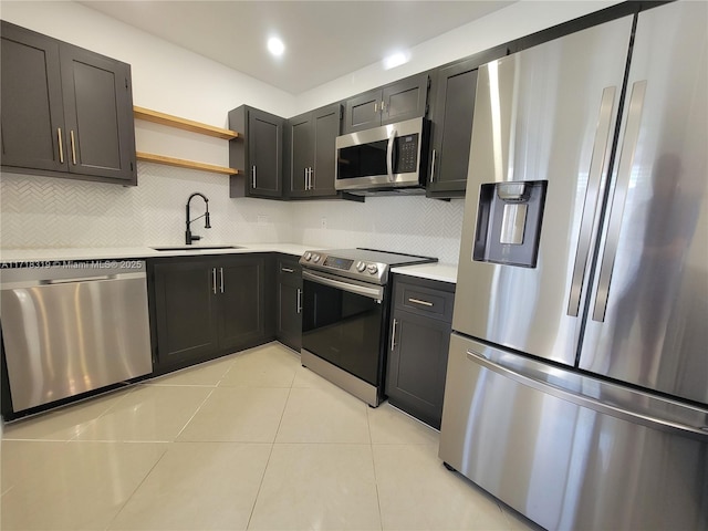 kitchen with decorative backsplash, appliances with stainless steel finishes, sink, and light tile patterned flooring