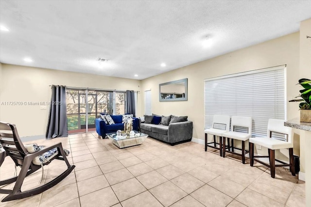 living room featuring a textured ceiling and light tile patterned flooring