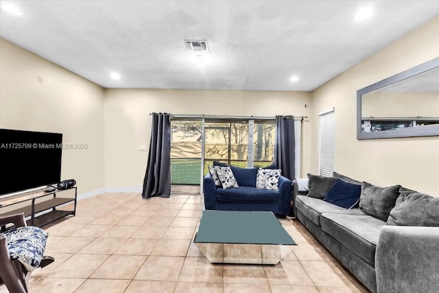 living room with a textured ceiling and light tile patterned flooring