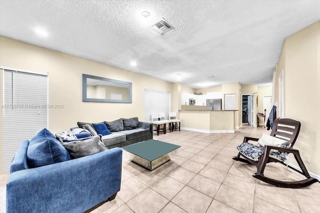 living room featuring a textured ceiling and light tile patterned floors