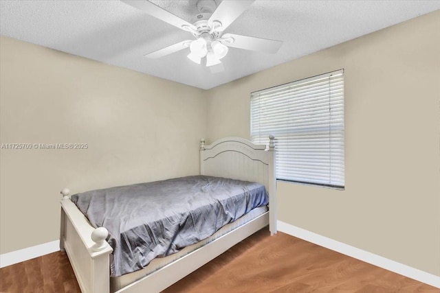 bedroom featuring a textured ceiling, ceiling fan, and dark hardwood / wood-style flooring