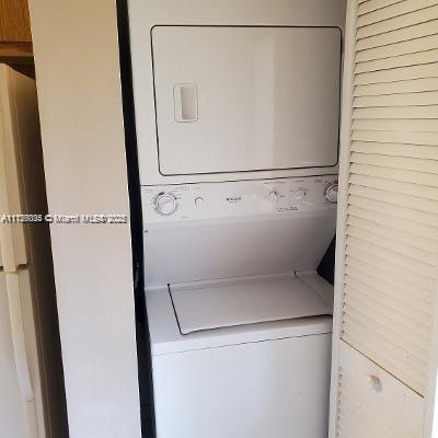 clothes washing area featuring stacked washer and dryer