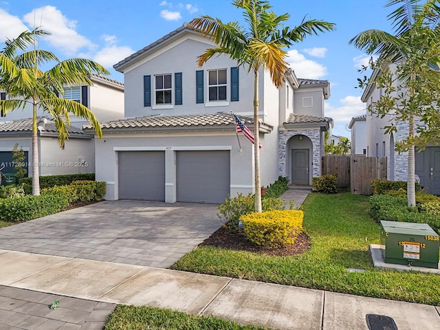 mediterranean / spanish-style house featuring a front yard and a garage