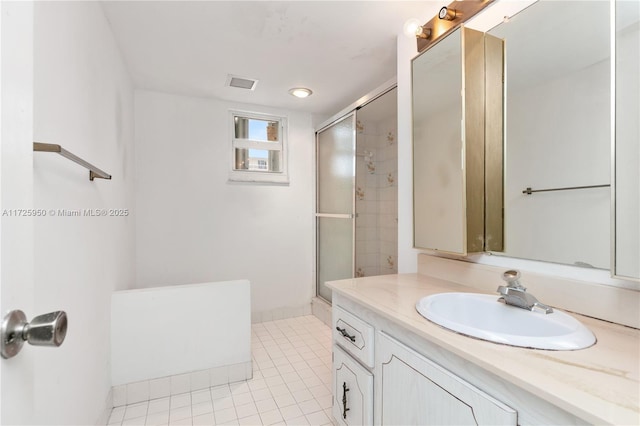 bathroom featuring tile patterned flooring, a shower with door, and vanity