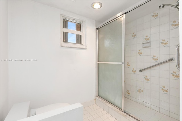 bathroom featuring toilet, tile patterned floors, and a shower with shower door