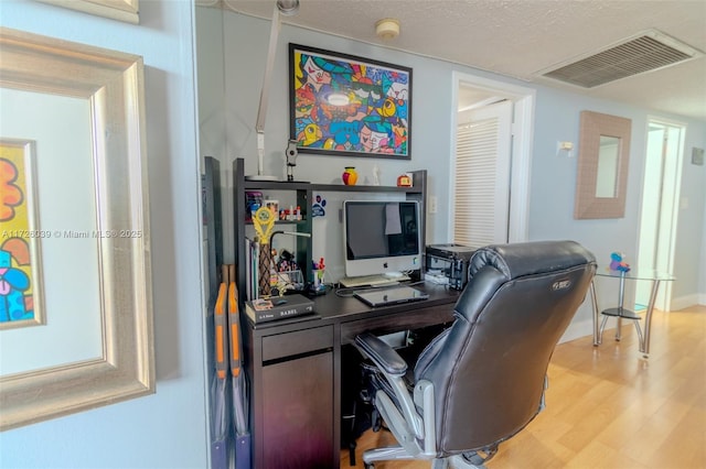 office space featuring light hardwood / wood-style floors and a textured ceiling