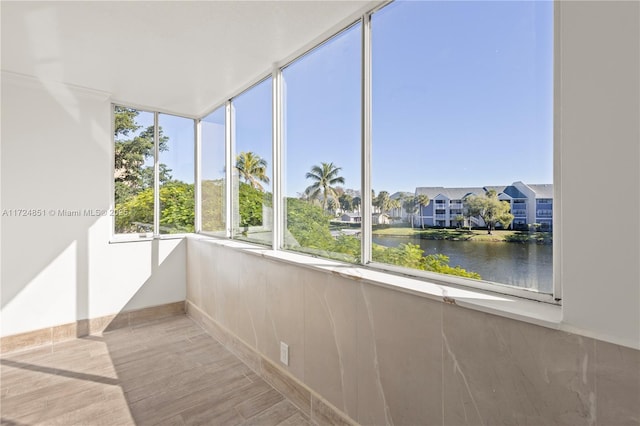 unfurnished sunroom featuring a water view