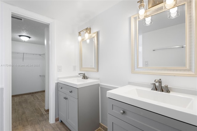 bathroom with vanity, a textured ceiling, and hardwood / wood-style flooring