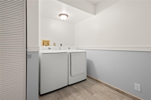 washroom featuring washing machine and dryer and light hardwood / wood-style floors