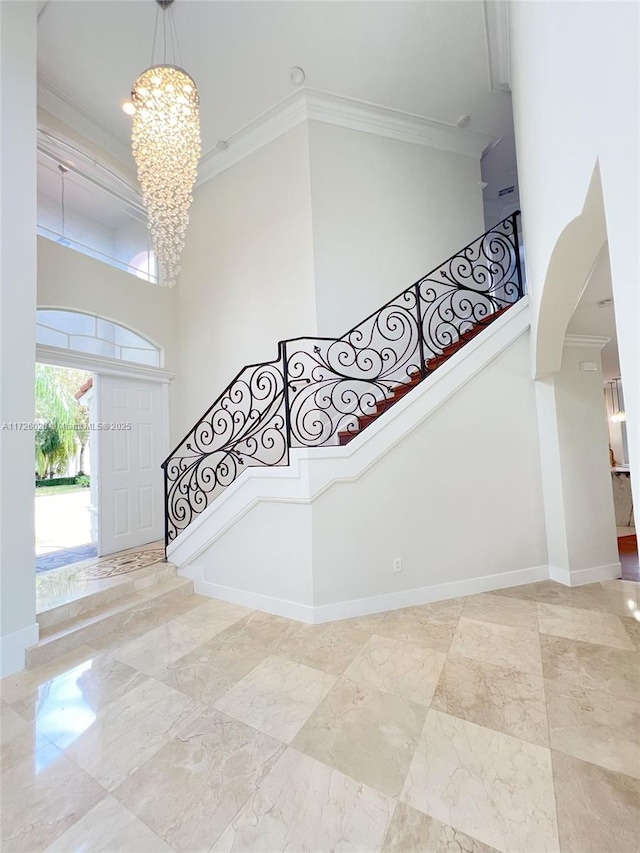 staircase with a notable chandelier and crown molding