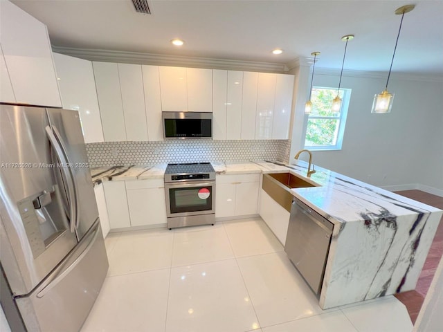 kitchen with white cabinetry, ornamental molding, decorative backsplash, pendant lighting, and appliances with stainless steel finishes