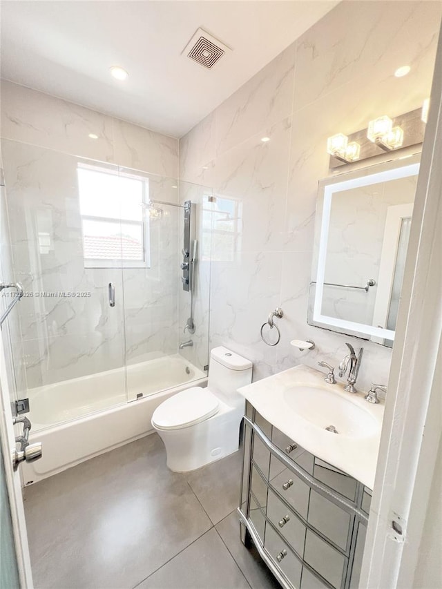 full bathroom with tile walls, toilet, tile patterned floors, enclosed tub / shower combo, and vanity