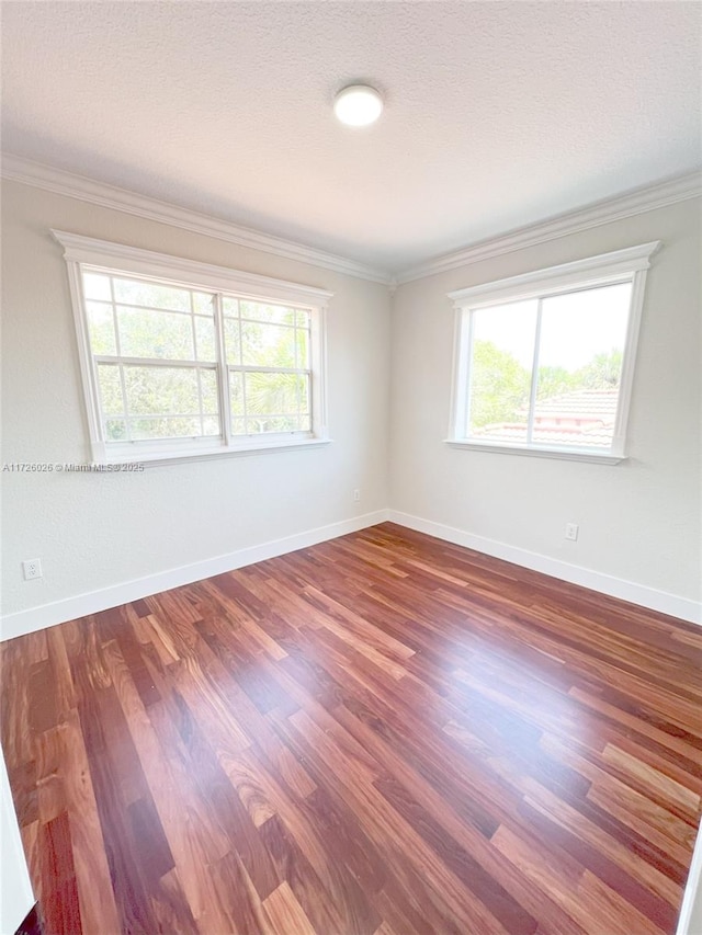 unfurnished room with plenty of natural light, a textured ceiling, ornamental molding, and hardwood / wood-style floors