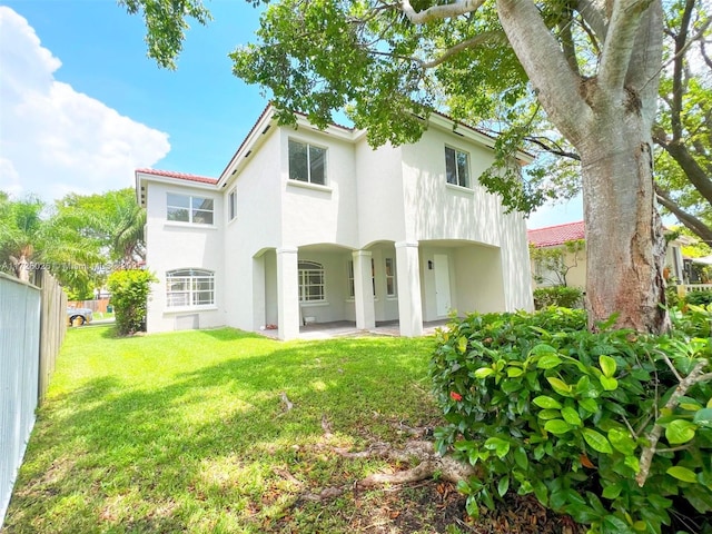 back of property with a yard and a patio area