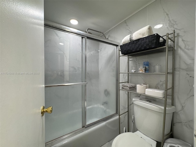 bathroom with combined bath / shower with glass door and toilet