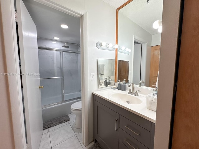 full bathroom featuring toilet, a textured ceiling, tile patterned flooring, bath / shower combo with glass door, and vanity