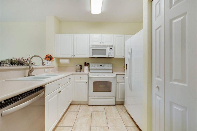 kitchen featuring white cabinetry, sink, white appliances, and light tile patterned floors