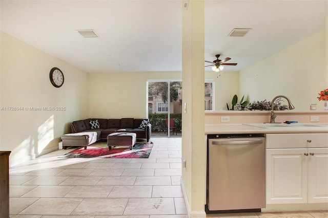 kitchen featuring light tile patterned flooring, sink, dishwasher, ceiling fan, and white cabinets