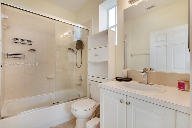 full bathroom featuring vanity, shower / bath combination with glass door, and toilet