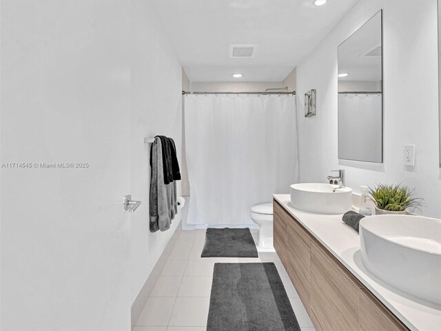 full bathroom featuring vanity, toilet, tile patterned flooring, and shower / bath combo