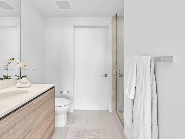 bathroom featuring tile patterned floors, toilet, an enclosed shower, and vanity