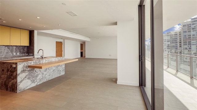 kitchen with sink, light hardwood / wood-style floors, backsplash, and floor to ceiling windows