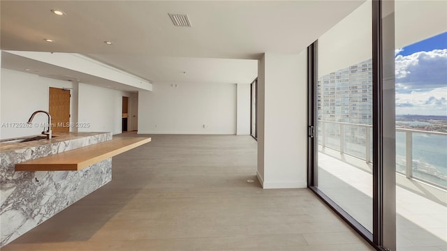 kitchen featuring a wall of windows and sink