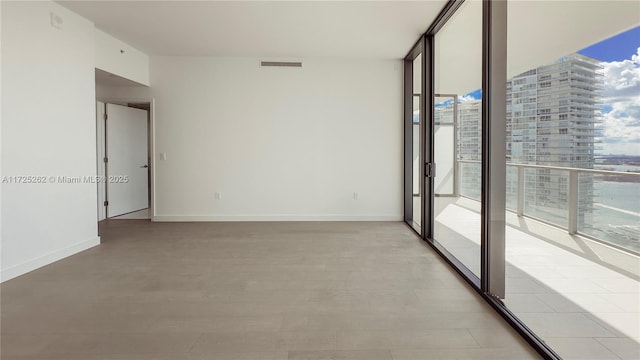 empty room with a wall of windows and a healthy amount of sunlight