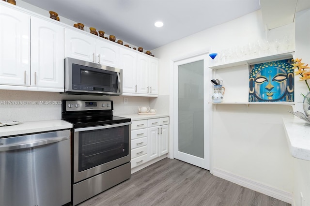 kitchen with appliances with stainless steel finishes, light hardwood / wood-style flooring, and white cabinetry