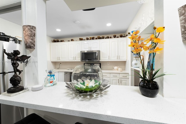 kitchen featuring white cabinets, stainless steel appliances, and kitchen peninsula