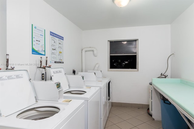 laundry area featuring light tile patterned floors and washer and clothes dryer