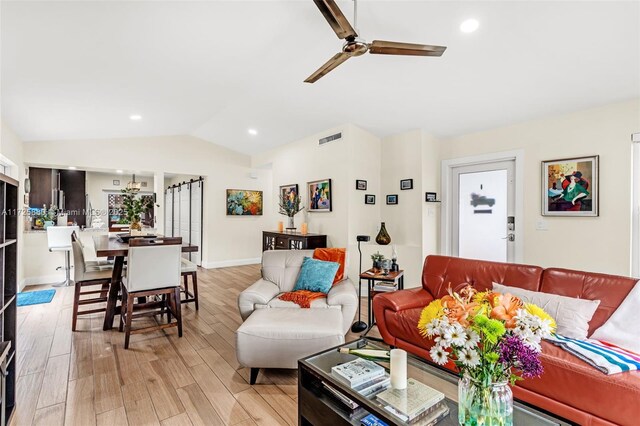 living room with vaulted ceiling, ceiling fan, and light hardwood / wood-style flooring