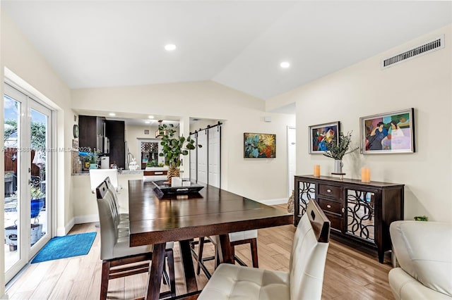 dining area featuring lofted ceiling, french doors, and light hardwood / wood-style floors