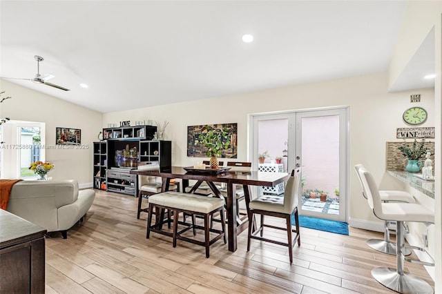 dining space with light wood-type flooring, french doors, vaulted ceiling, and baseboards