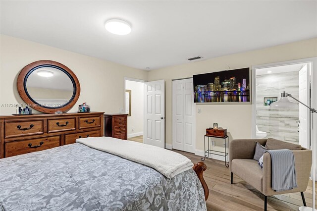 bedroom featuring ensuite bath and light hardwood / wood-style floors